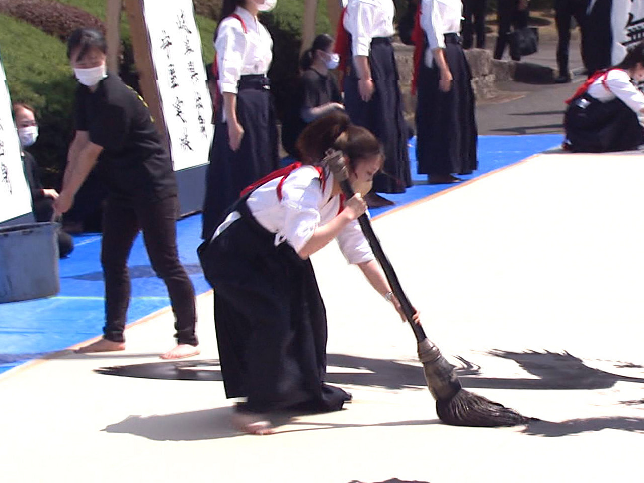 岐阜市の岐阜女子大学で4日、入学式が行われ、書道部の学生が特大の書を書き上げるパ...