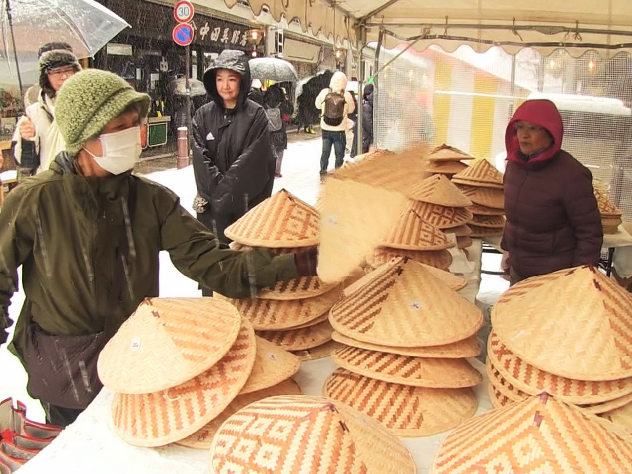 飛騨高山の冬の風物詩「二十四日市」が２４日、吹雪の中で開催され、伝統工芸品を買い...