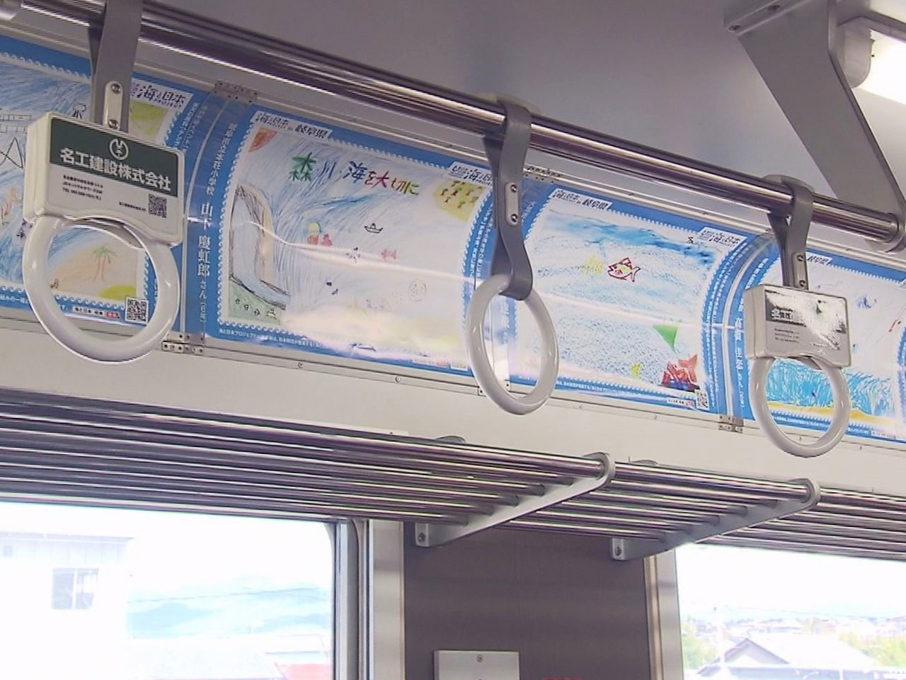 海なし県の子どもたちが理想の海を描いたポスターが、明知鉄道の列車内に展示されてい...